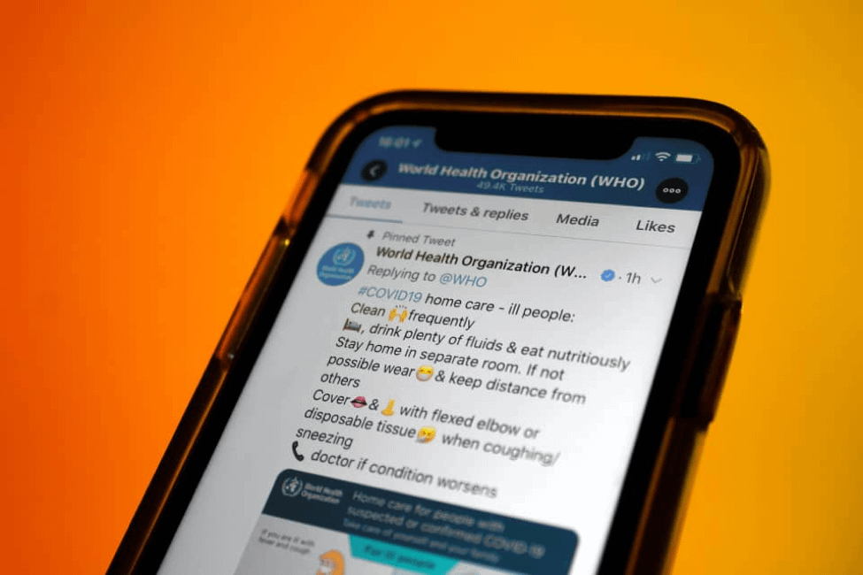 Phone showing tweets from World Health Organization